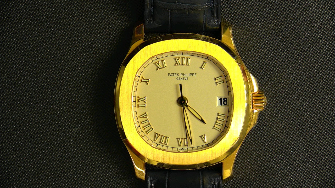 Patek Philippe 5060 with a black strap on a dark textured background