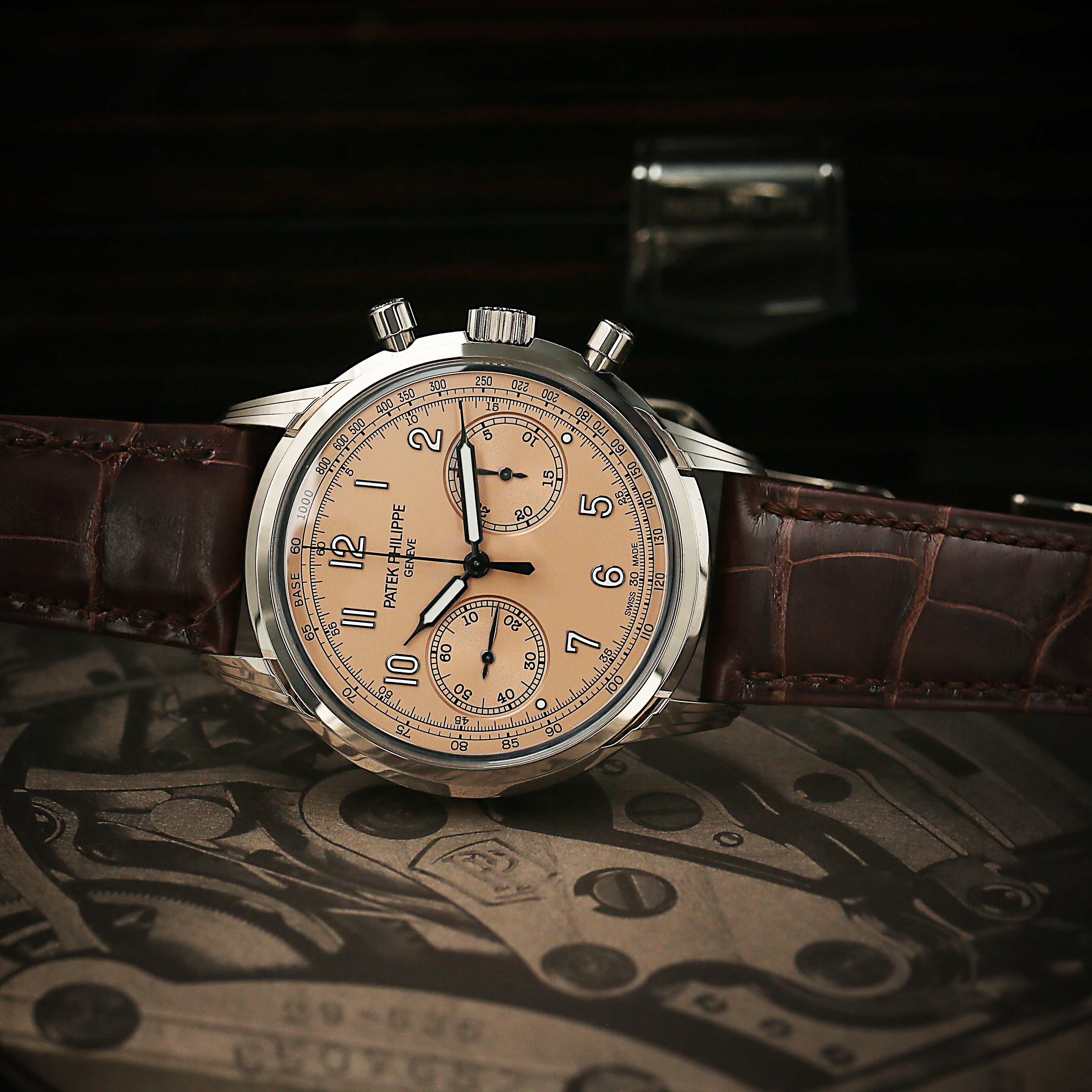 Patek Philippe watch with brown leather strap and detailed face on a dark background